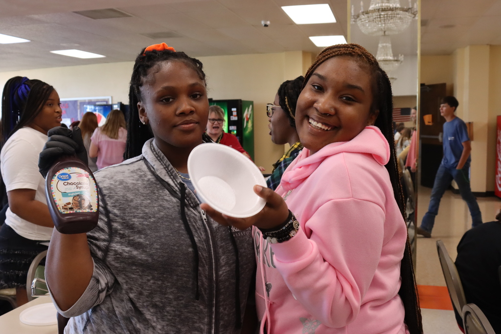 Two students with ice cream bowl and syrup