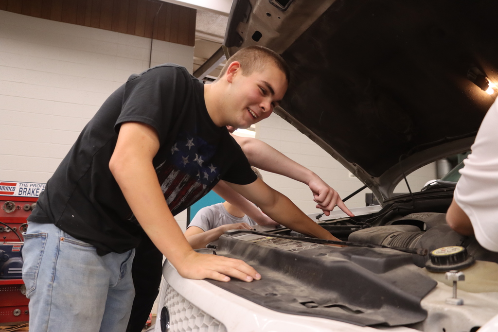Students under the hood  of a vehicle